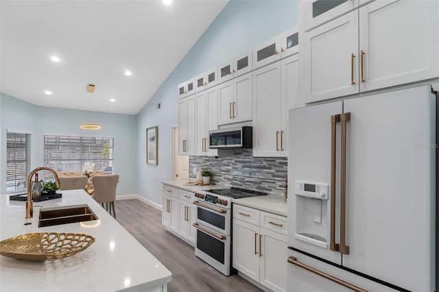 kitchen featuring white appliances, white cabinetry, sink, and pendant lighting