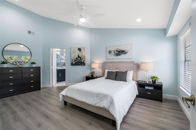 bedroom with ensuite bath, high vaulted ceiling, hardwood / wood-style floors, and ceiling fan