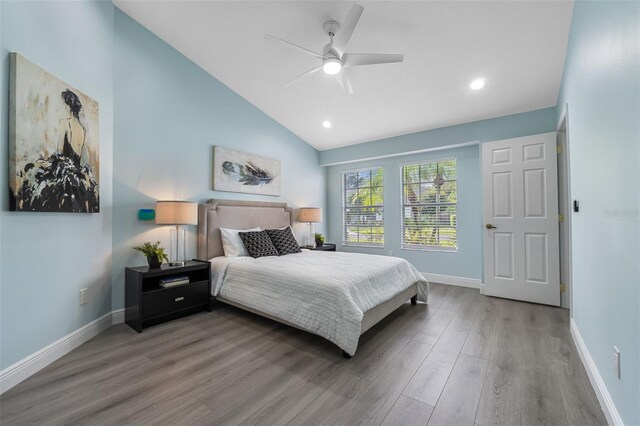 bedroom with ceiling fan, lofted ceiling, and hardwood / wood-style flooring