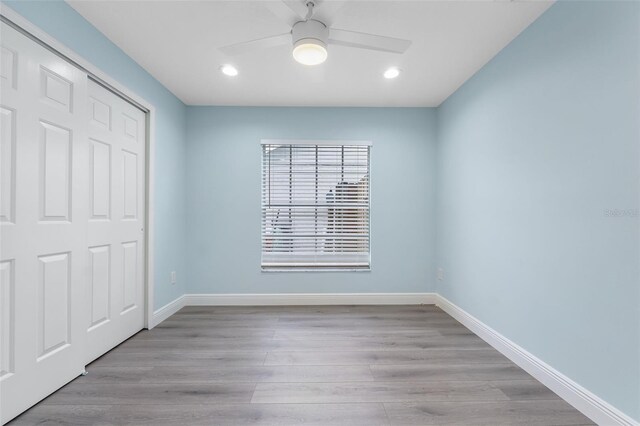 unfurnished bedroom with light hardwood / wood-style flooring, a closet, and ceiling fan