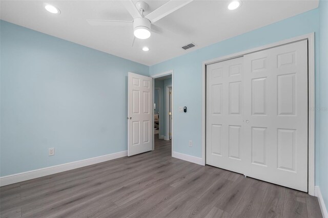 unfurnished bedroom featuring ceiling fan, hardwood / wood-style floors, and a closet