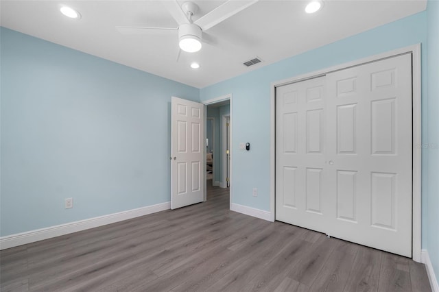 unfurnished bedroom featuring light hardwood / wood-style floors, a closet, and ceiling fan