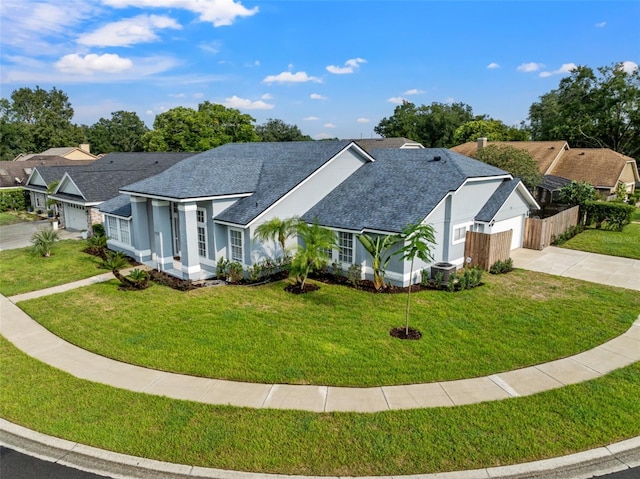 ranch-style home featuring a front yard, cooling unit, and a garage