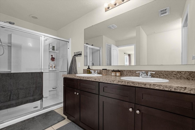 bathroom with tile patterned floors, vanity, and an enclosed shower