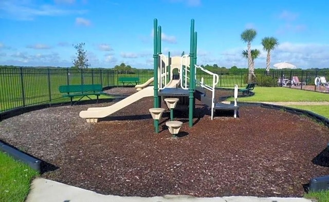 community jungle gym with a yard and fence