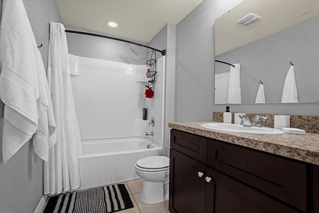 full bathroom featuring tile patterned floors, vanity, a textured ceiling, shower / bath combo with shower curtain, and toilet