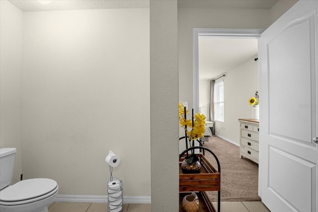 bathroom featuring tile patterned flooring, baseboards, and toilet