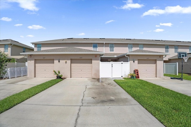 view of property featuring a garage, a gate, fence, and stucco siding