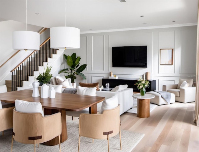 dining space featuring light hardwood / wood-style floors and ornamental molding