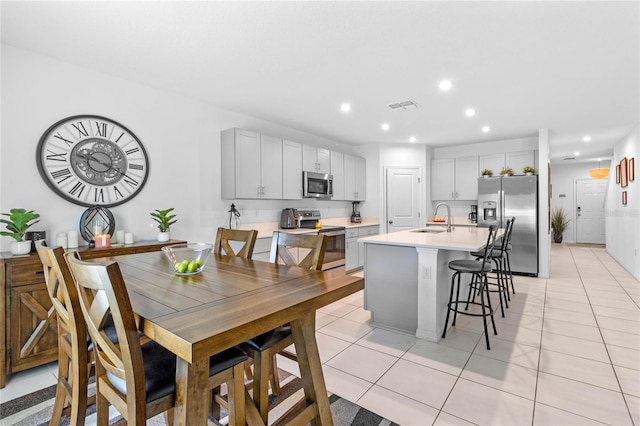 dining space with sink and light tile patterned floors