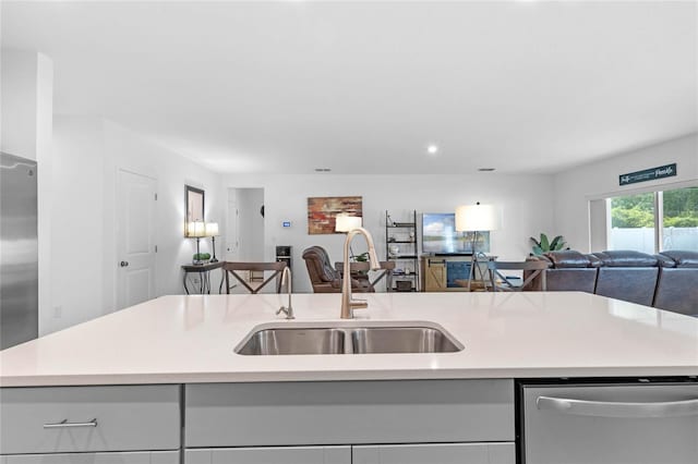 kitchen with sink, a kitchen island with sink, and stainless steel appliances