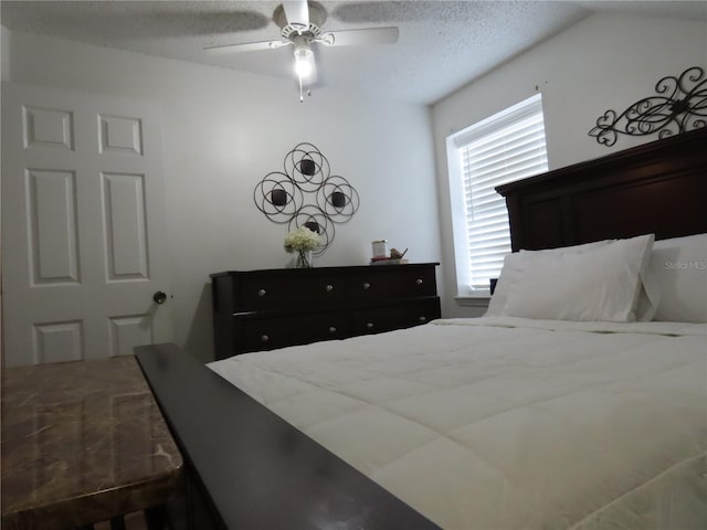 bedroom with ceiling fan and a textured ceiling