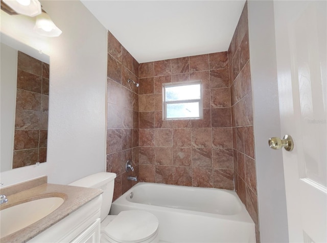 full bathroom featuring tiled shower / bath combo, vanity, and toilet