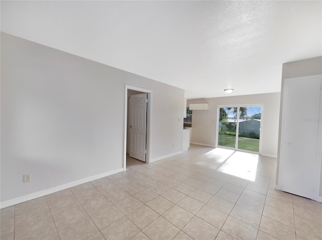 spare room with light tile patterned flooring and a textured ceiling