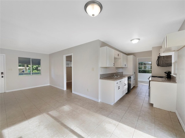 kitchen with sink, dishwasher, dark stone countertops, white cabinets, and light tile patterned flooring