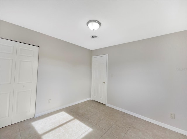 unfurnished bedroom with light tile patterned floors and a closet