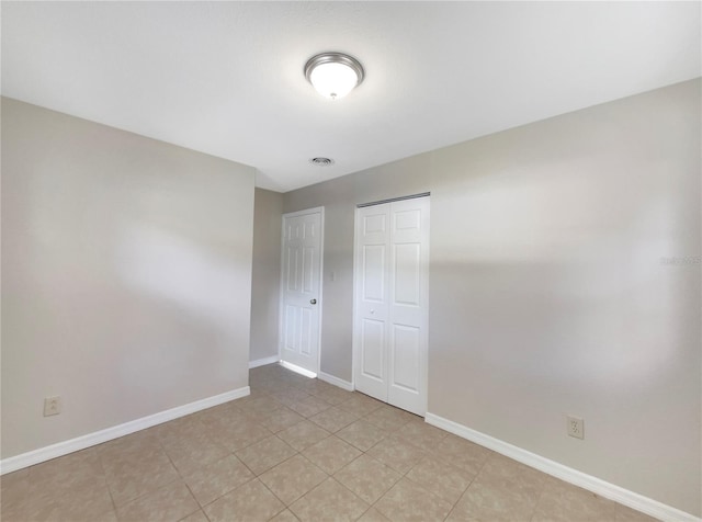 unfurnished bedroom featuring light tile patterned floors and a closet