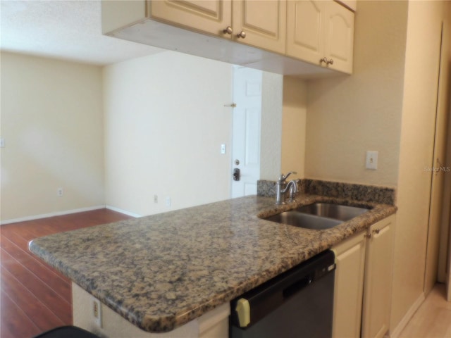 kitchen with sink, dark hardwood / wood-style flooring, kitchen peninsula, dark stone countertops, and dishwashing machine