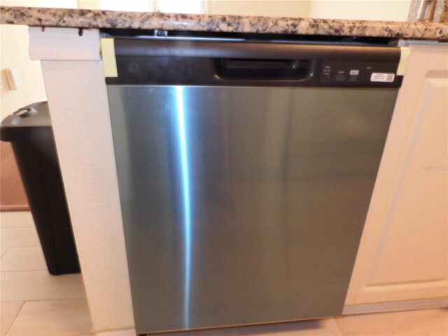 room details with white cabinetry and stainless steel dishwasher