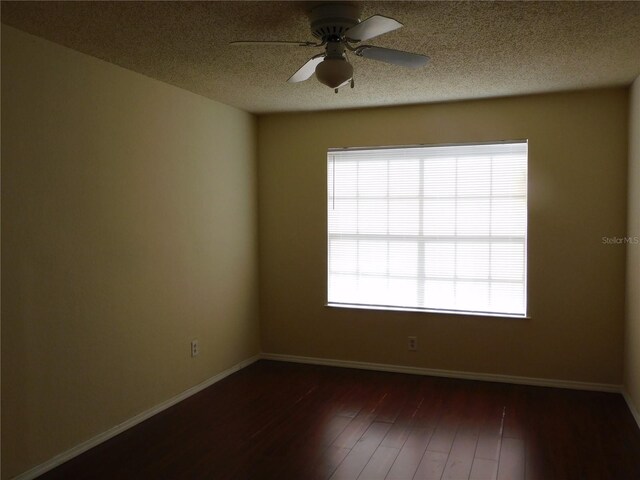 spare room with ceiling fan, dark wood-type flooring, and a textured ceiling