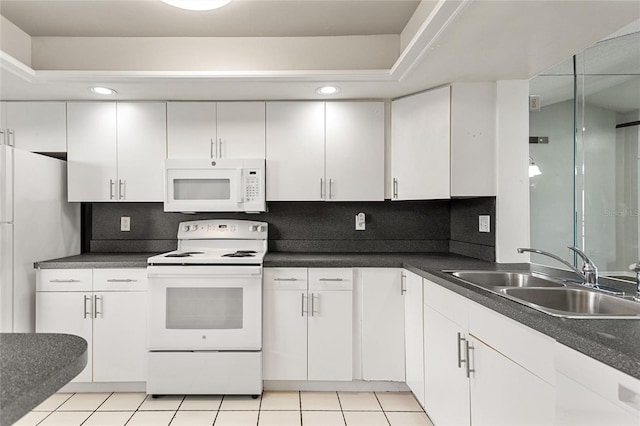 kitchen featuring white appliances, white cabinets, sink, backsplash, and light tile patterned floors