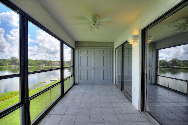 unfurnished sunroom featuring a water view and ceiling fan