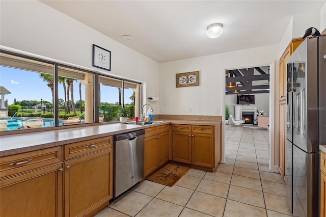 kitchen featuring light tile patterned flooring, dishwasher, fridge, and sink