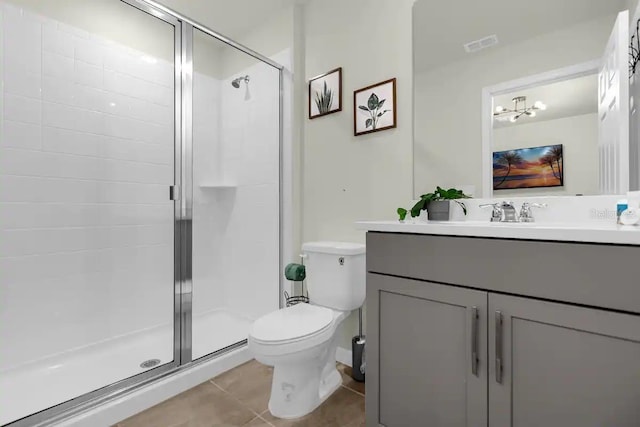 bathroom featuring vanity, an enclosed shower, tile patterned flooring, and toilet