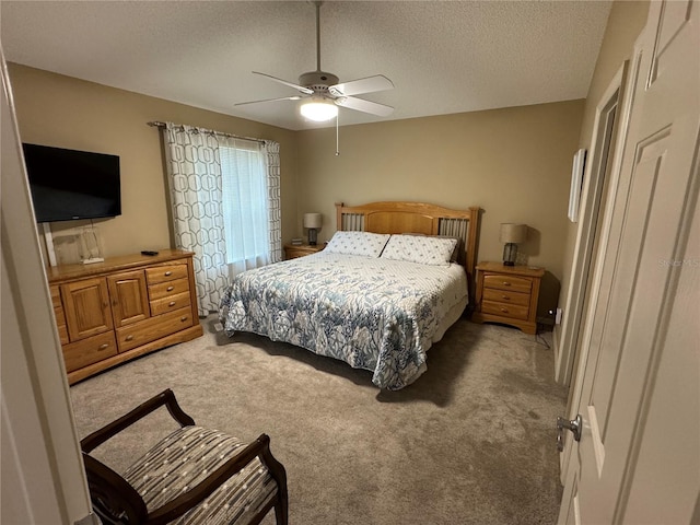 bedroom with ceiling fan, light carpet, and a textured ceiling