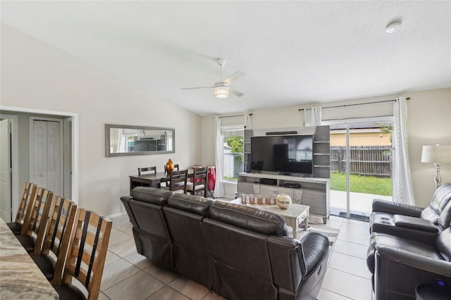 tiled living room featuring ceiling fan and high vaulted ceiling