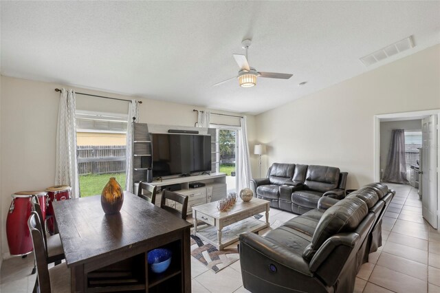 tiled living room featuring a textured ceiling and ceiling fan