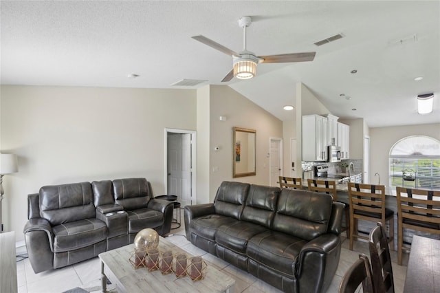 living room featuring light tile patterned flooring, ceiling fan, and high vaulted ceiling