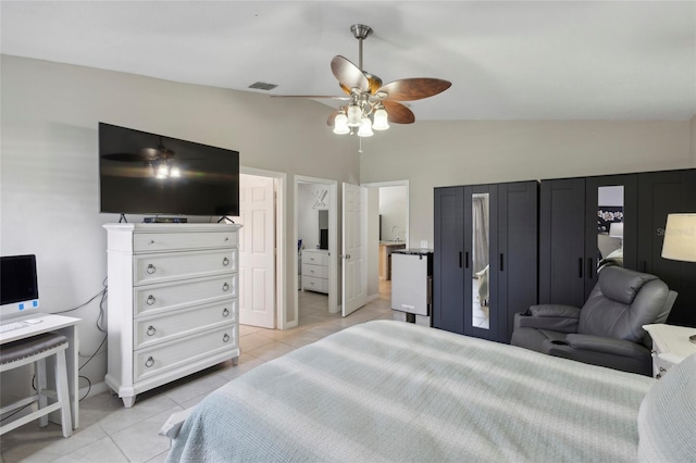 bedroom featuring ceiling fan, light tile patterned flooring, and vaulted ceiling