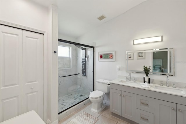 bathroom with a shower with shower door, dual vanity, tile patterned flooring, and toilet