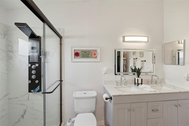 bathroom featuring an enclosed shower, double vanity, and toilet