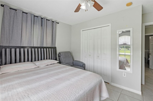 bedroom with light tile patterned floors, a closet, and ceiling fan