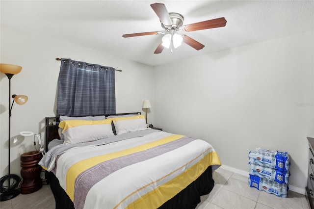 tiled bedroom featuring ceiling fan and a textured ceiling