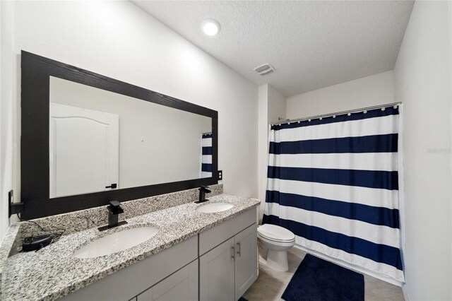 bathroom featuring vanity, curtained shower, toilet, and a textured ceiling