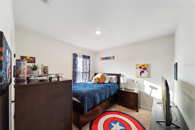 bedroom featuring light carpet and a textured ceiling