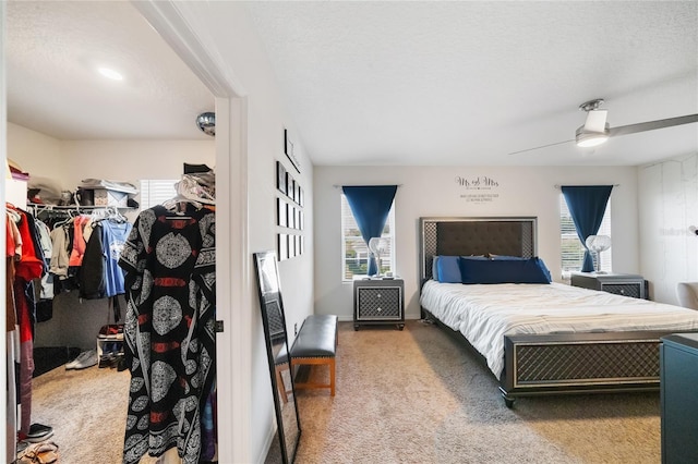 bedroom featuring a closet, dark carpet, multiple windows, and ceiling fan