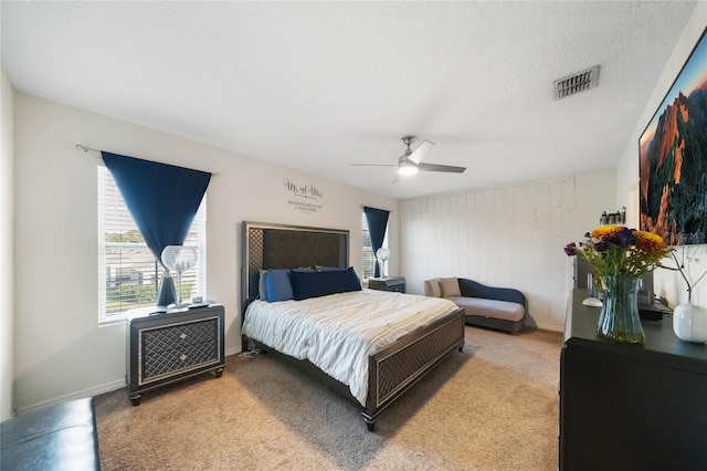 bedroom with carpet flooring, ceiling fan, and a textured ceiling