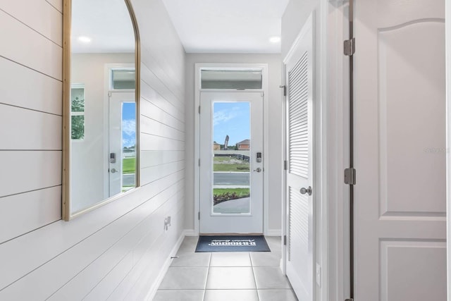 entryway featuring light tile patterned flooring and wood walls