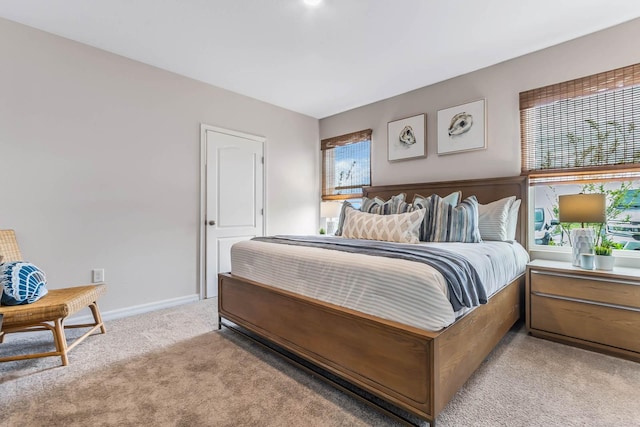 bedroom with multiple windows and light colored carpet