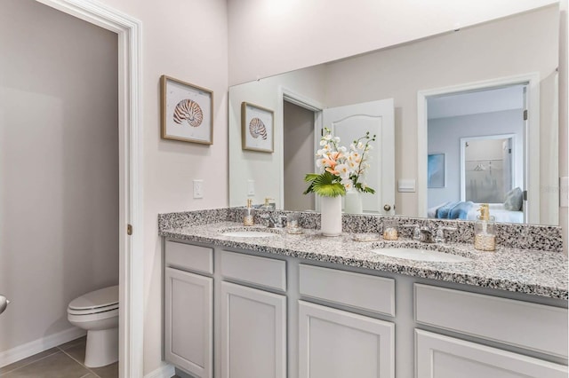 bathroom featuring tile patterned floors, dual bowl vanity, and toilet