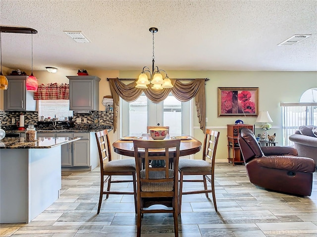 dining room featuring a textured ceiling, a chandelier, and light tile patterned floors