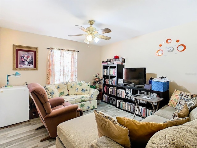 living room with ceiling fan and light hardwood / wood-style flooring