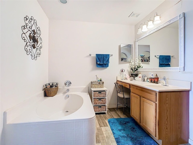 bathroom featuring a bath, hardwood / wood-style flooring, and vanity