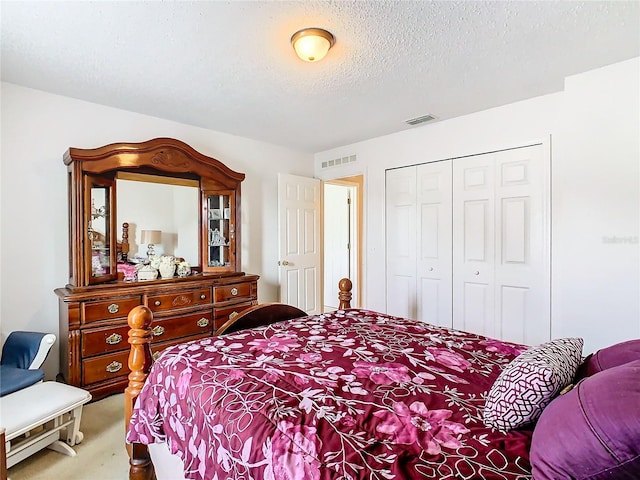 carpeted bedroom featuring a textured ceiling and a closet