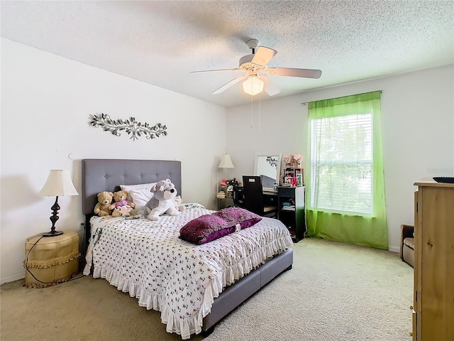 carpeted bedroom with ceiling fan and a textured ceiling