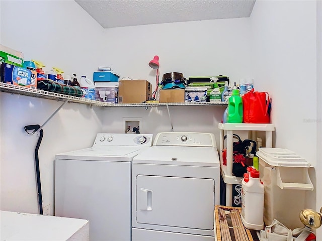 laundry room with a textured ceiling and washing machine and clothes dryer